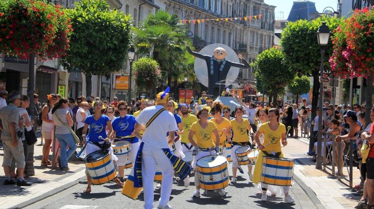 Une banda en jaune et bleu qui déambule dans la rue principale de Tarbes sous le regard du public sur les trottoirs